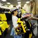 Michigan fan Corey Karp, of Tucson, AZ., shows his mom Iris, an item as they shop before an autograph signing with football star Desmond Howard at the M Den on Friday.  Melanie Maxwell I AnnArbor.com